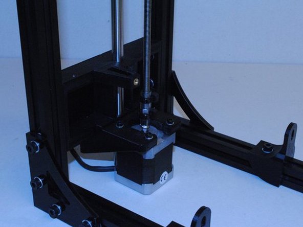 Lift up the X/Z axis until you can bolt the Z nut holder to the X end motor.
