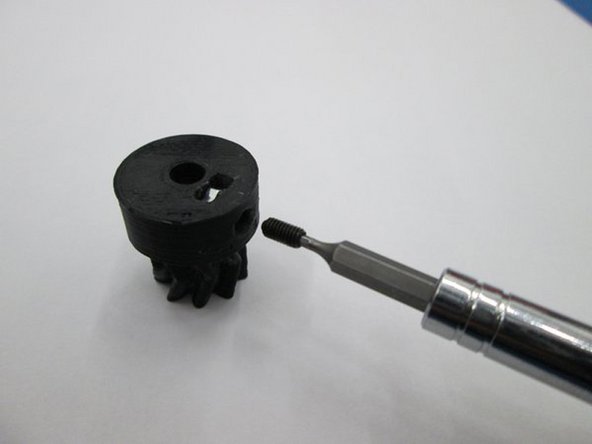 Install the M3 nut into the bottom of the small herringbone gear.