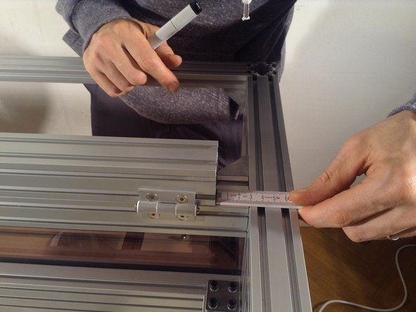 Mount the 4040 extrusion top door frame, and it should be 2.8 cm off edge on each side.