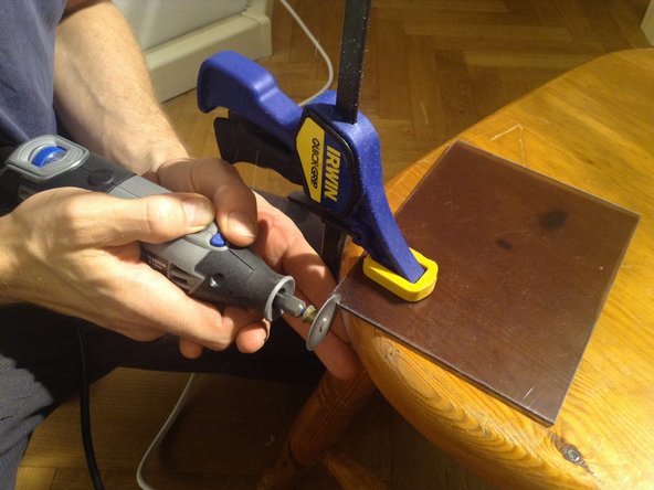 Cut the corner out with a dremel tool. The corner cutout allows the panel to fit against the walls of the frame.