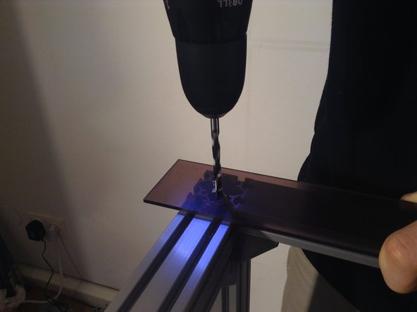 The two 6 cm wide tinted glazing pieces serve as a seal for the door. Mark hole locations and drill bolt holes through these, and mount to the hinged 4040 extrusion.