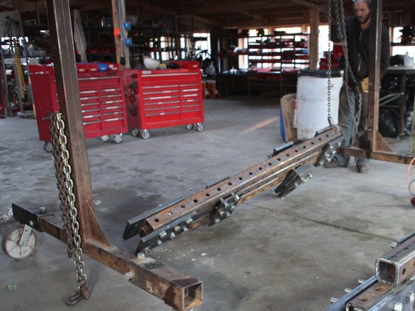 Turn the upper frame upside down so that the pivot plates are resting on the ground.