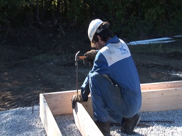 Once foundation is level and square, drive stakes into inner corners to keep the foundation in place. We used pieces of 1/2" rebar for this, because we had lots on hand. You could also use wooden stakes.