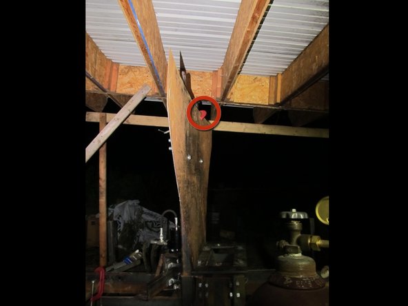 It should be centered horizontally between them, and touching the supports all the way down to the hopper mounting plate.