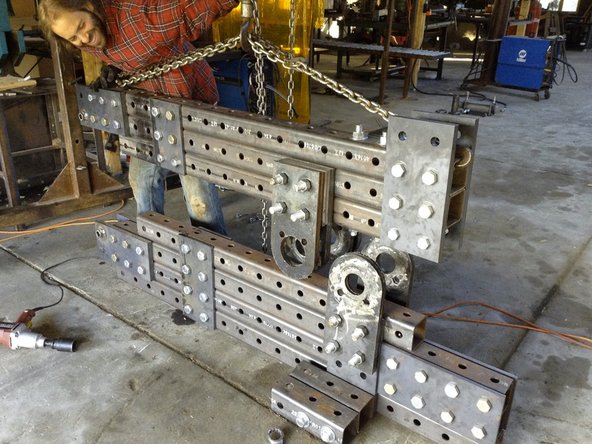 Use the hoist to lift the upper frame into place, making sure the pivot plate holes roughly align.