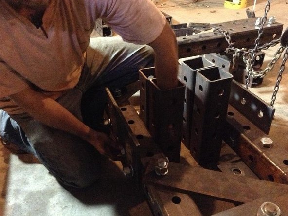 Insert bolts through the tube (bolts should not pass through the 4" space between the Main Pivot Tubes because the pivot cylinders will move through this space).