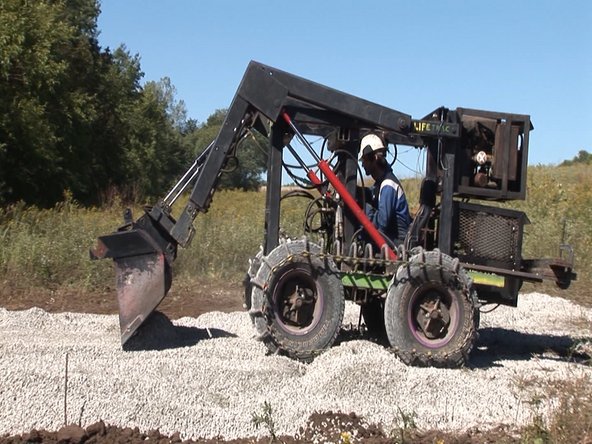 Flatten gravel into a level pad. The foundation formwork will be built on top of this pad.