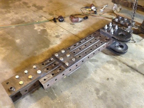 Turn the upper frame upside down so that the pivot plates are resting on the ground.