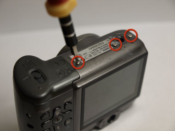 Disassembling Canon PowerShot A590 IS Front Cover, Remove Bottom Screws: step 6, image 1 of 1